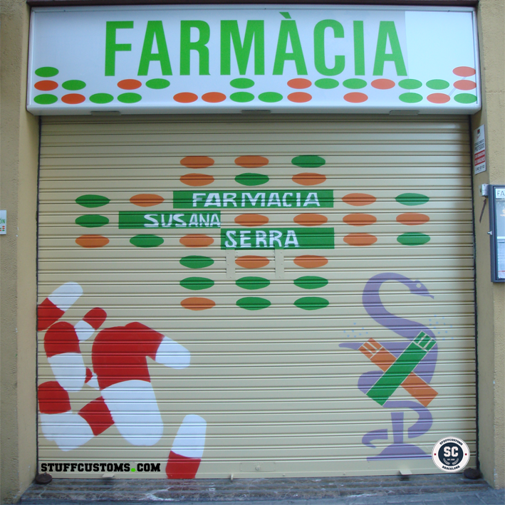 Graffiti comercial con diseño de farmacia realizado a mano por Stuff Customs en la persiana de la Farmacia Susana Serra en Barcelona