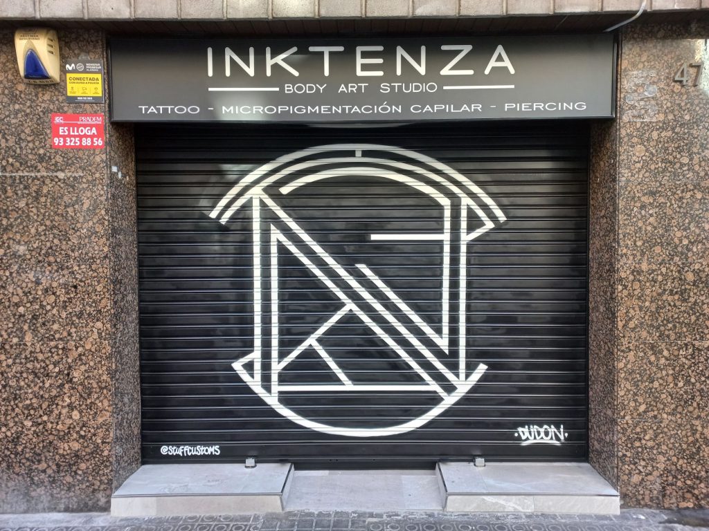 graffiti de logotipo en persiana metálica de estudio de tatuajes en Barcelona