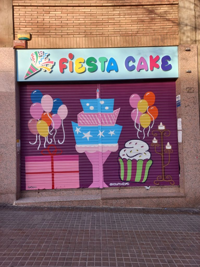 Decoración de persianas comerciales dobles pintadas a mano, rotulación de alta visibilidad para tiendas en barrios de Barcelona.