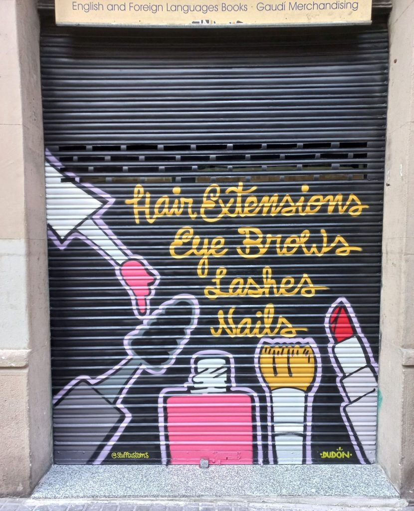 Graffiti profesional aplicado en persiana metálica con agujeros arriba en Barcelona