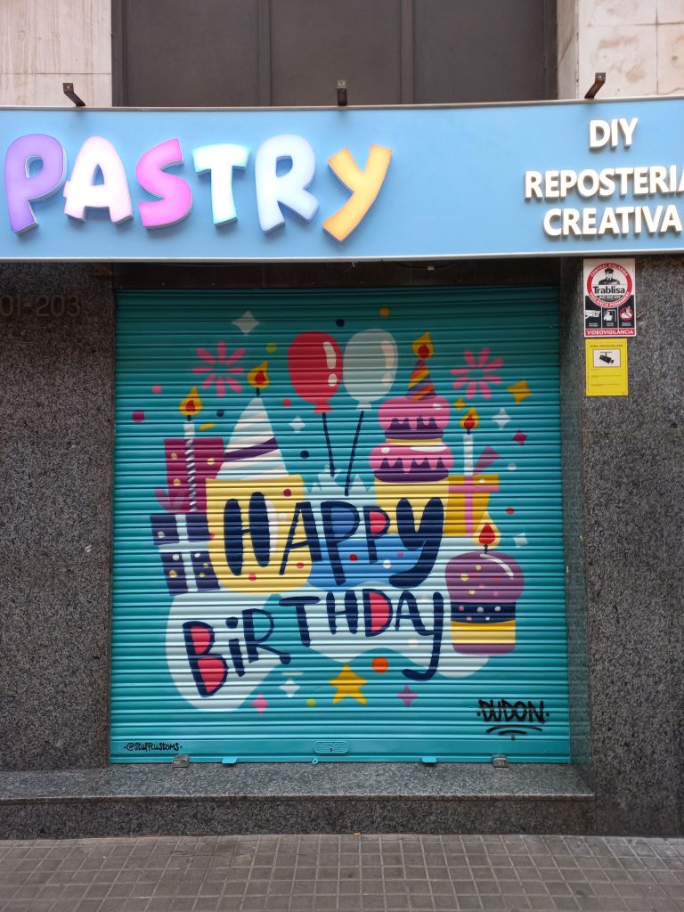 Graffiti estilo artístico en persiana de comercio en L'Hospitalet de Llobregat, Barcelona