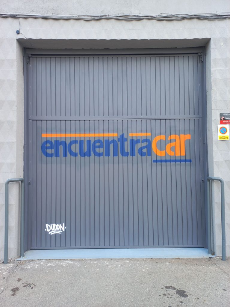 graffiti de logotipo en persiana metálica grande para venta de vehículos en Barcelona