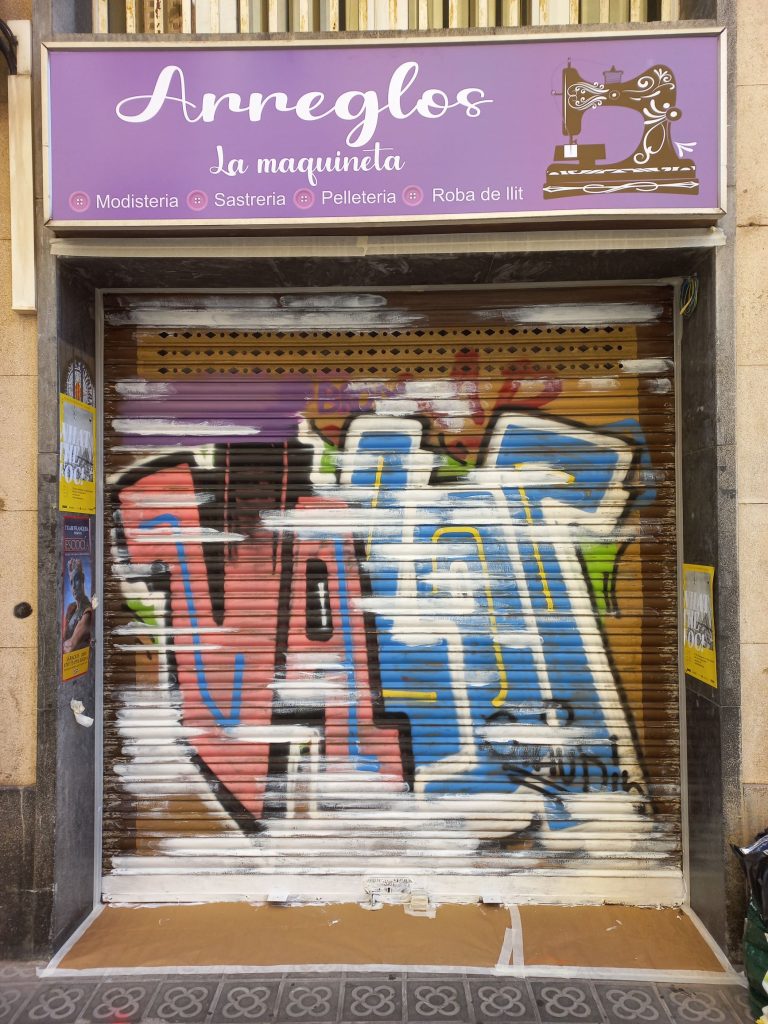 Reparación de desconchado con parcheado de imprimación en persiana con graffiti profesional