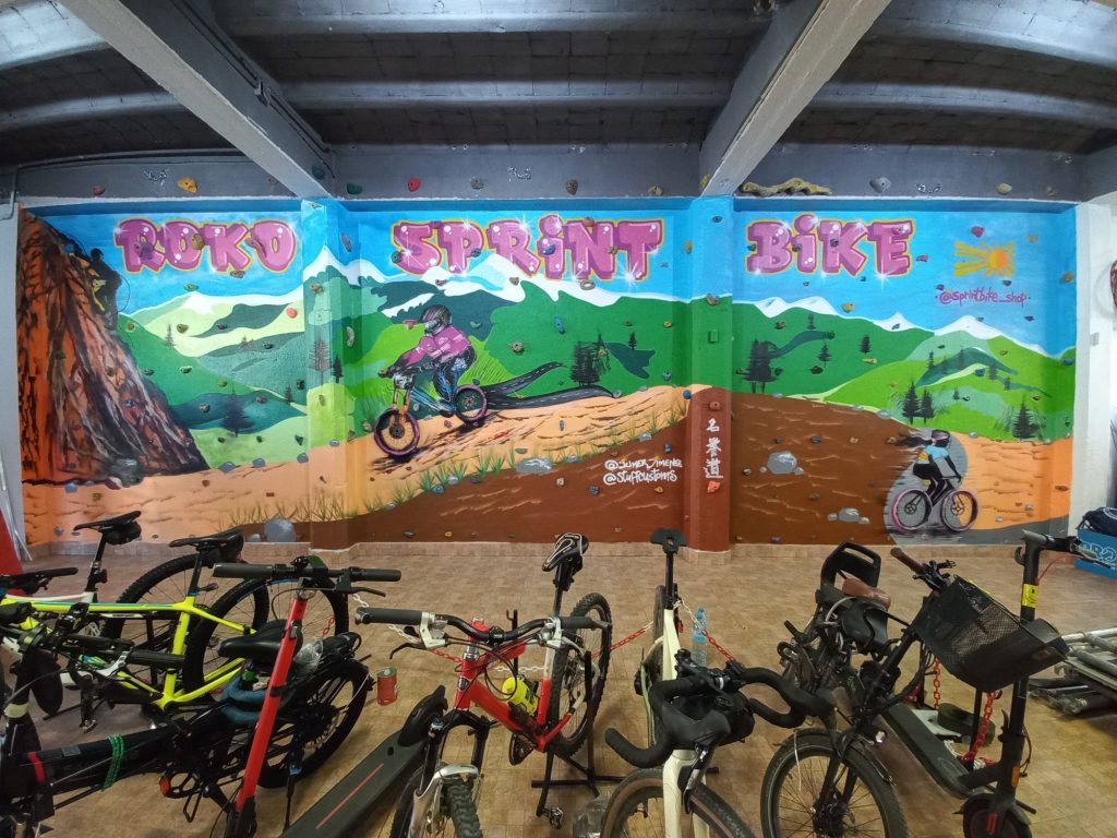 mural graffiti interior en tienda de bicicletas con decoración tipo rocódromo