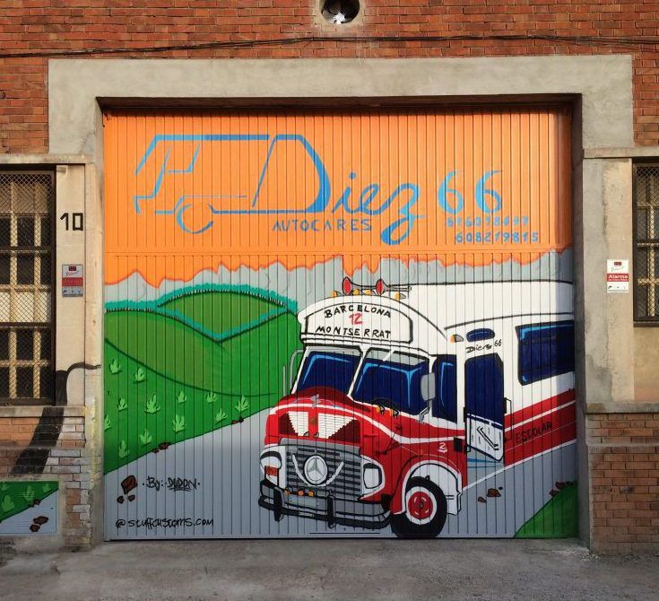 Graffiti artístico pintado a mano en puerta basculante gigante de nave industrial para empresa de autocares