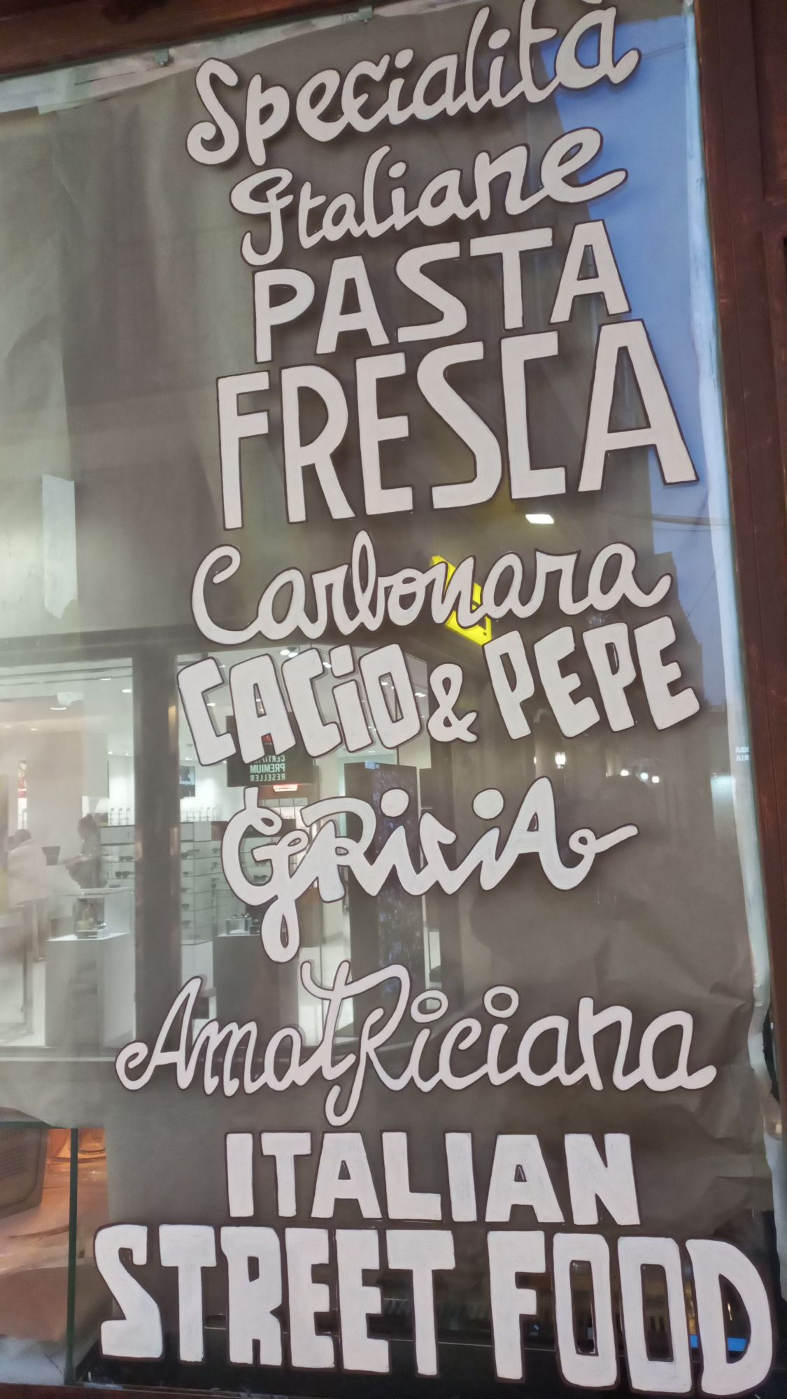 Lettering artesanal pintado a mano sobre cristal para restaurante italiano moderno en Badalona, diseño único sin vinilos.