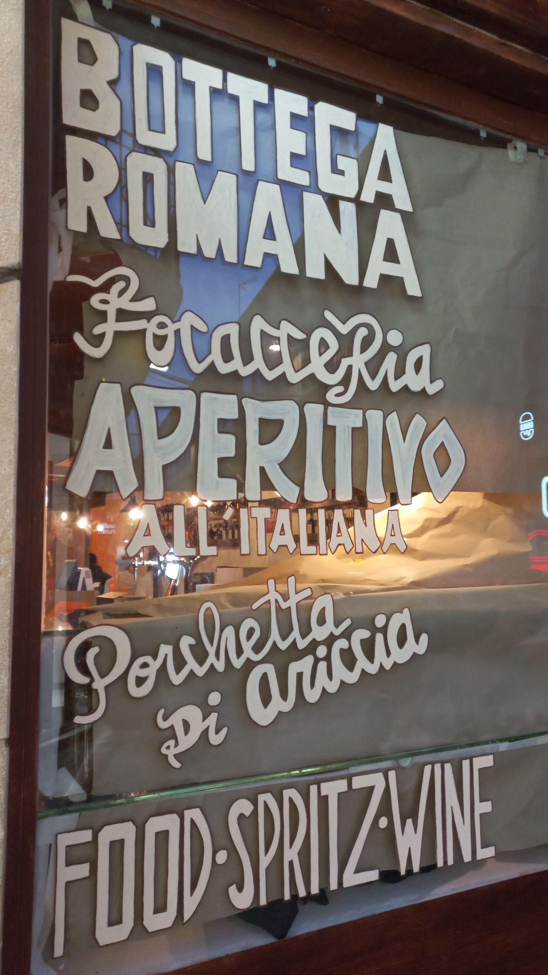 Rotulación decorativa manual en fachada de restaurante italiano vanguardista en Badalona, acabado profesional a mano.