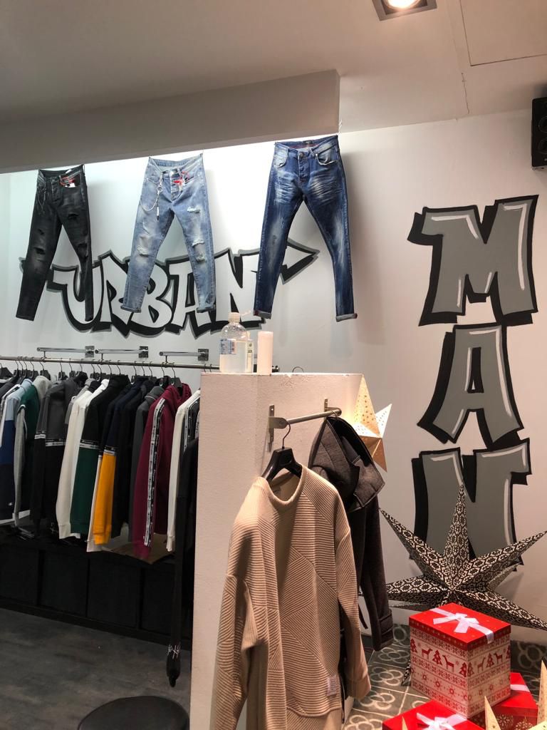 Graffiti lettering artístico en pared interior en tienda de moda en Sant Andreu, Barcelona