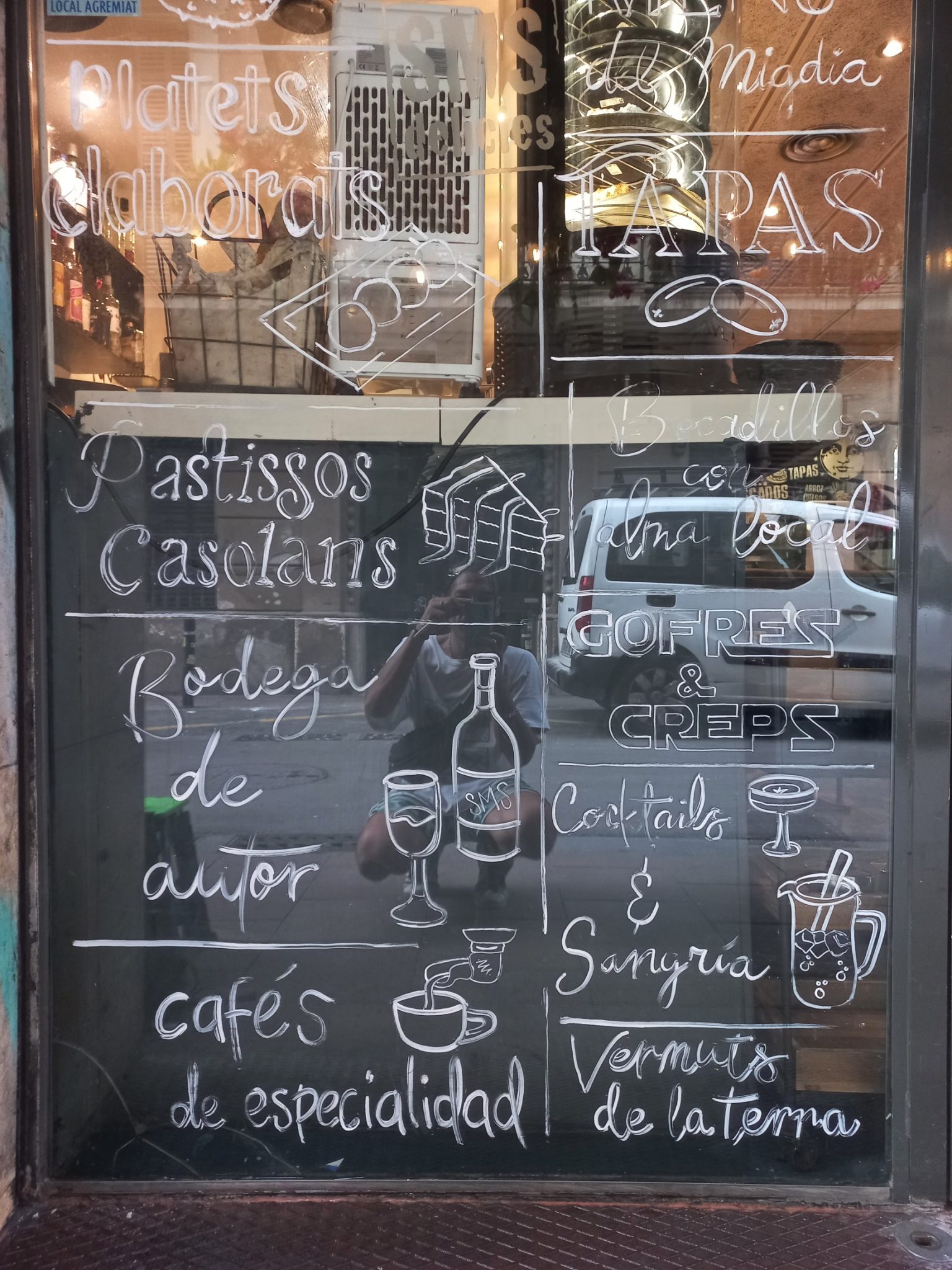 Pintura a mano alzada en cristales para local de brunch moderno en Gràcia, rotulación artesanal personalizada.
