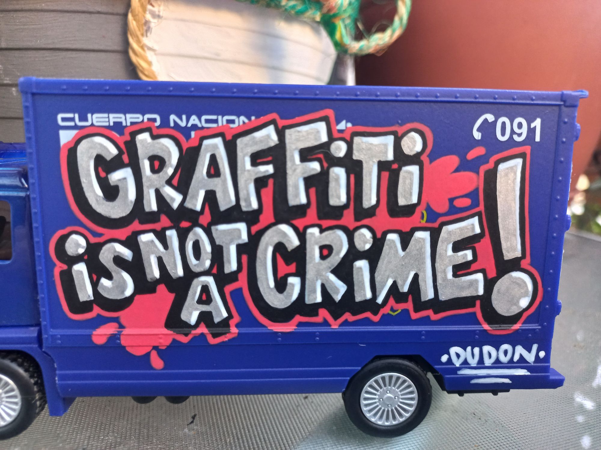 Primer plano de los detalles decorativos y firmas estilo graffiti sobre un vehículo de juguete, técnica de precisión con rotuladores por stuffcustoms.