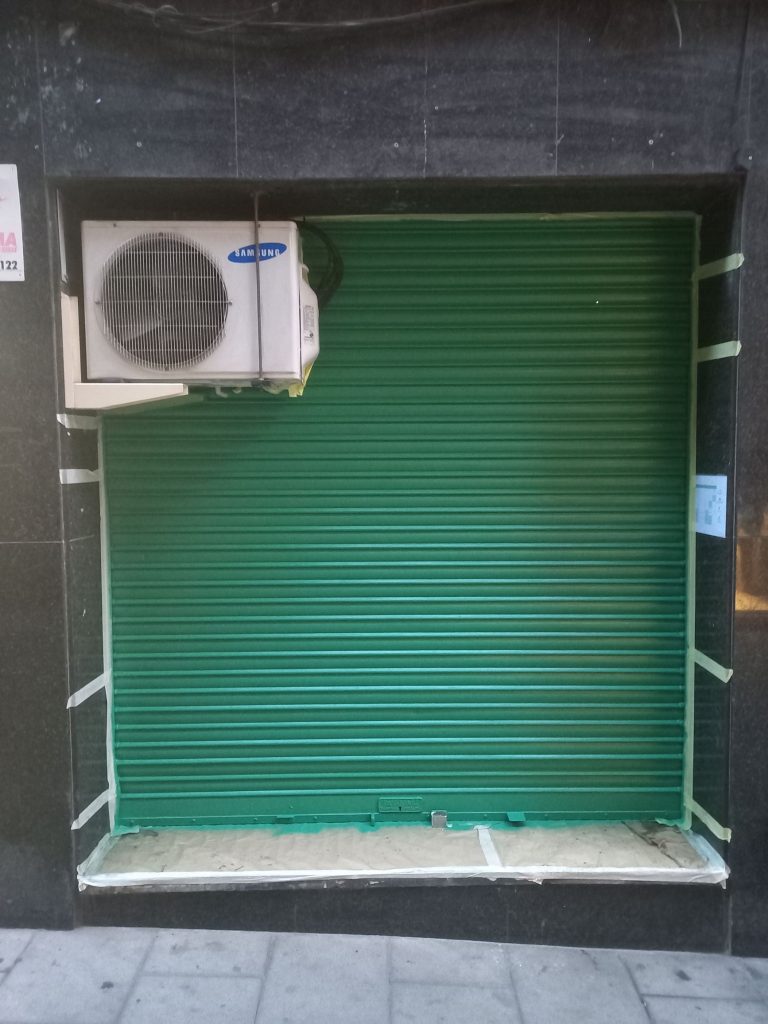 Aplicación de pintura profesional monocolor verde claro en persiana.