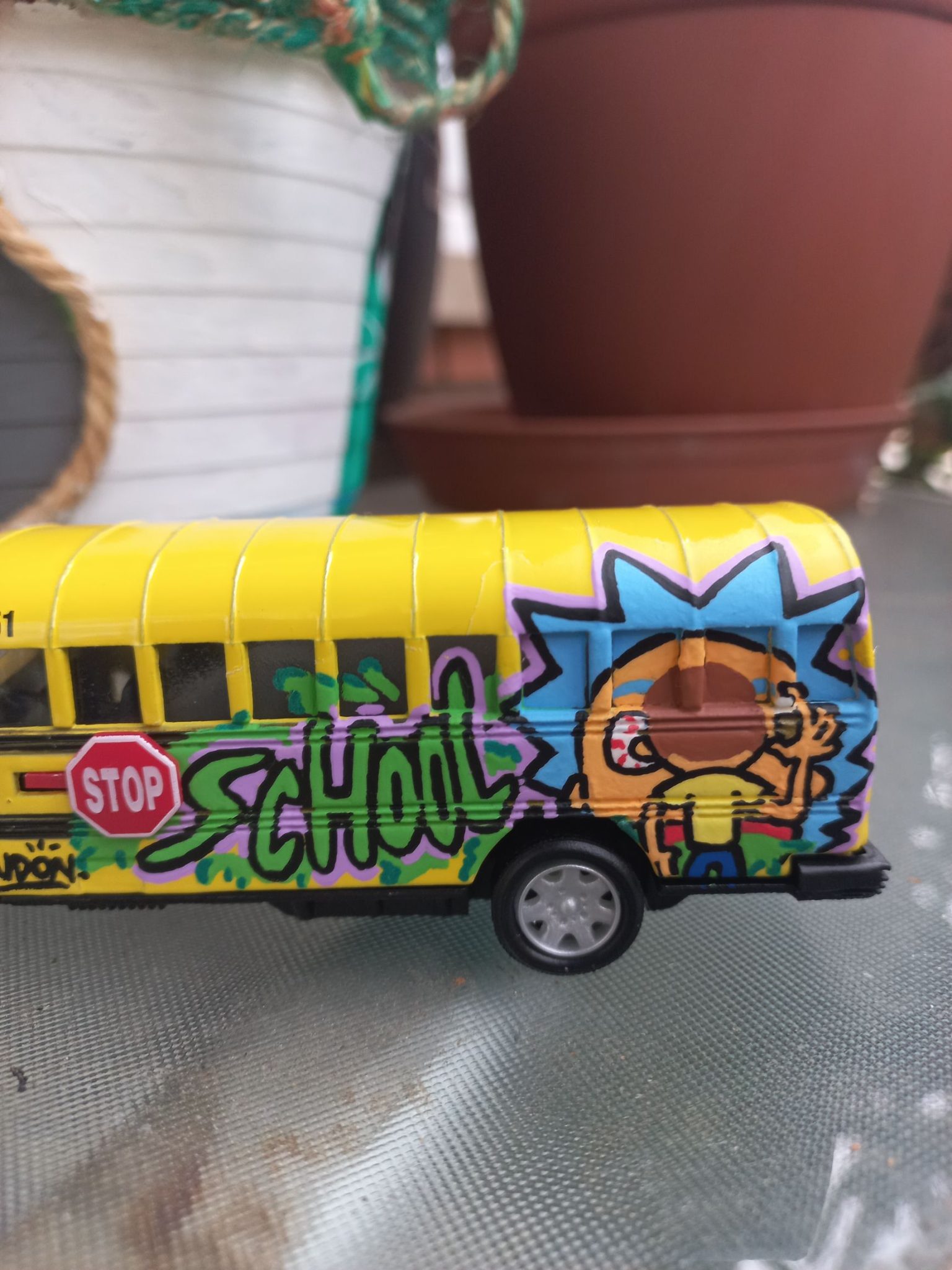 Zoom a los detalles del graffiti en miniatura sobre la carrocería del coche custom, mostrando la precisión de los trazos y el estilo cartoon de stuffcustoms.