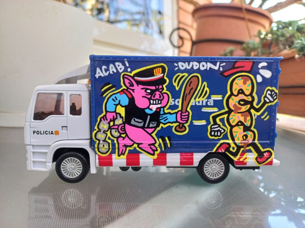 Zoom a los detalles laterales de la furgoneta de Mossos d'Esquadra, mostrando la precisión de los rotuladores y el estilo urbano aplicado por stuffcustoms.