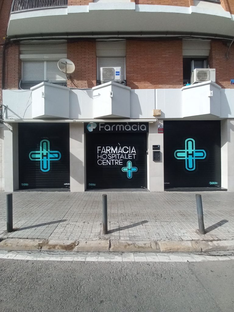 Conjunto de tres persianas metálicas pintadas con graffiti profesional para una farmacia en Hospitalet de Llobregat, diseño unificado y corporativo por stuffcustoms.